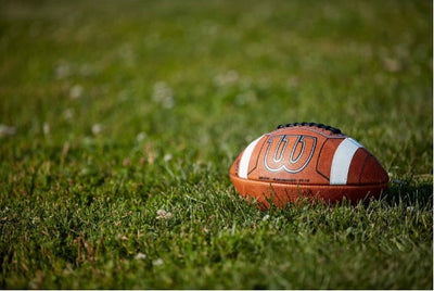 Wilson GST Prime Football with enhanced grip and high visibility accents on grass field